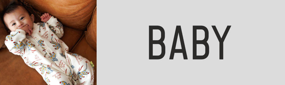 犬の柄のロンパスを着たベビーが寝ています。ベビーサイズのお洋服のカテゴリーページへのリンクです。